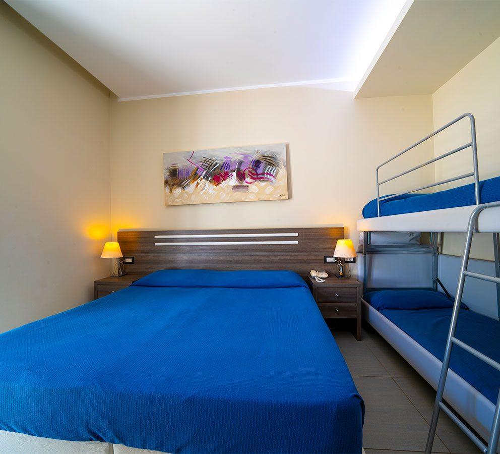 Camera con letto matrimoniale e castello, decorata con arte astratta e lampade calde.